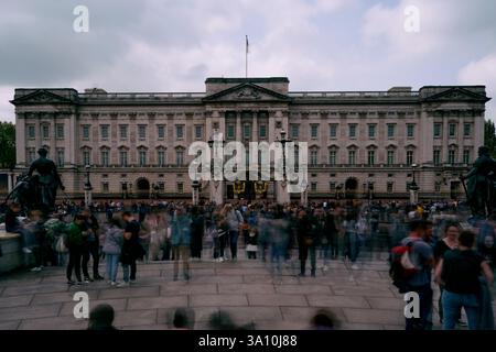 A large crowd of tourists gathered in front of the main facade of Buckingham Palace under an overcast sky, London, Greater London, England, United Kin Stock Photo