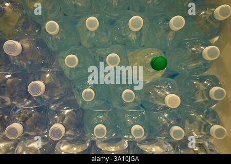 Close-up of plastic water bottles stacked in a crate with a green cap detail, Lorica, Sila National Park, Italy. Stock Photo