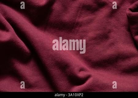Red synthetic fabric with folds as background, red soft warm fabric, red clothes Stock Photo