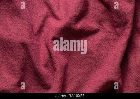 Red synthetic fabric fleecy with folds as background, red soft warm fabric, red clothes Stock Photo