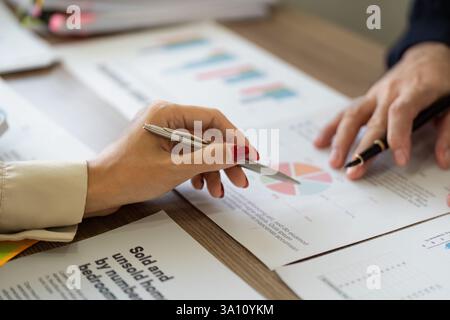 Team members discussing financial reports and analyzing data with charts and graphs. Stock Photo