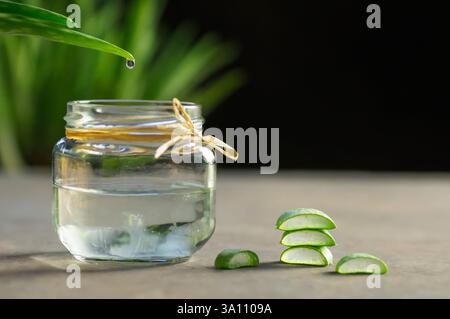 Aloe Vera gel close-up. Sliced Aloe vera plants leaf and gel with wooden spoon , natural organic cosmetic ingredients for sensitive skin Stock Photo