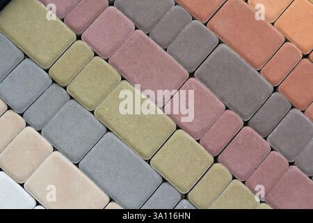Multicolored paving slabs for road paving by mosaic on shop window. Construction Stock Photo