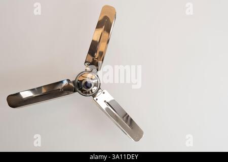 Shiny ceiling fan on light gray background. Seen from below Stock Photo