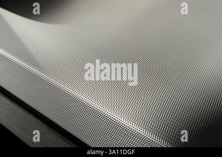 Background of stretched finely perforated steel with geometric shapes. Narrow depth of field, selective focus Stock Photo