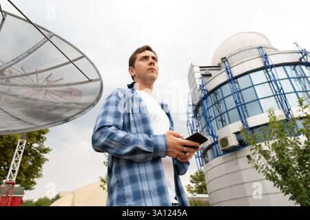 Engineer at work: a specialist tests mobile communication after detecting a malfunction, ensuring stable and reliable service. Stock Photo