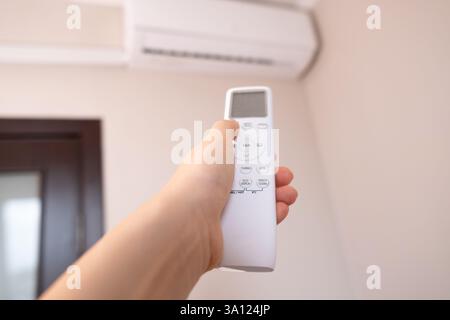 Woman controls smart home with a remote, creating a comfortable atmosphere in her home. Stock Photo