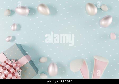 Easter scene with pastel eggs, a gift box, and bunny ears on a blue polka dot background. 3d rendering Stock Photo