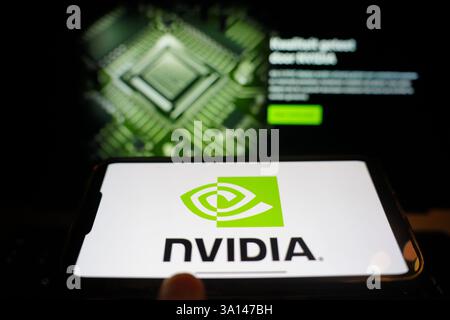 Roosendaal, The Netherlands - March 6, 2025: A mobile phone displaying the logo of NVIDIA, with the company website in the background. Stock Photo