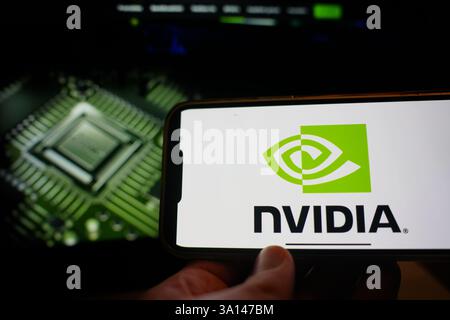 Roosendaal, The Netherlands - March 6, 2025: A mobile phone displaying the logo of NVIDIA, with the company website in the background. Stock Photo