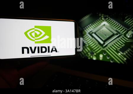 Roosendaal, The Netherlands - March 6, 2025: A mobile phone displaying the logo of NVIDIA, with the company website in the background. Stock Photo
