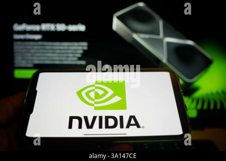 Roosendaal, The Netherlands - March 6, 2025: A mobile phone displaying the logo of NVIDIA, with the company website in the background. Stock Photo