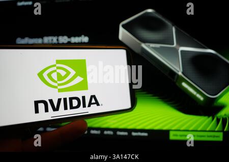 Roosendaal, The Netherlands - March 6, 2025: A mobile phone displaying the logo of NVIDIA, with the company website in the background. Stock Photo