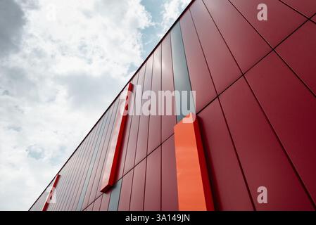 Looking up at the red building wall and clear blue sky in the background. Stock Photo