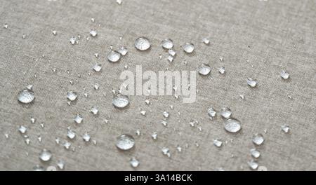Water drops on a beige water-repellent fabric. Stock Photo