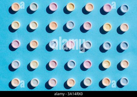 Top view of edible tablets of different colors. Sugar tablets on blue background. Stock Photo