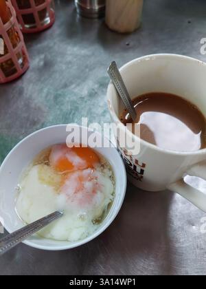 Breakfast food with soft-boiled eggs and vintage coffee Thai style for sale at Thai street food market or Thai vintage style coffee shop restaurant in Stock Photo