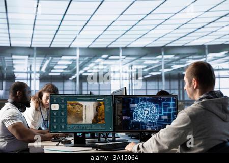 Team of programmers in server room making generative artificial intelligence website generating videos using diffusion models. Teamworking colleagues coding AI virtual assistant producing clips Stock Photo