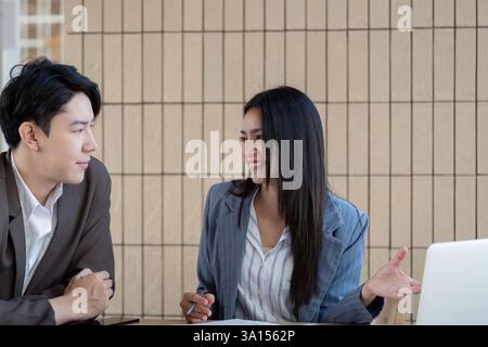 Professional collaboration. Two business professionals engaging in a discussion while analyzing project plans and strategies. Stock Photo