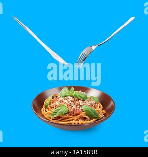 Cutlery in air over plate with tasty pasta bolognese on blue background Stock Photo