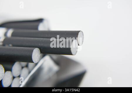 Cigarettes in a box on a white background close-up. Cigarettes with black filter. Smoking, Smoke Stock Photo