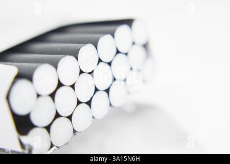 Cigarettes in a box on a white background close-up. Cigarettes with black filter. Smoking, Smoke Stock Photo