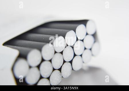 Cigarettes in a box on a white background close-up. Cigarettes with black filter. Smoking, Smoke Stock Photo