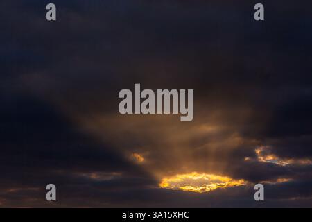 Textur Himmel dunkle Wolken mit Wolkenloch und durchscheinender Sonne Stock Photo