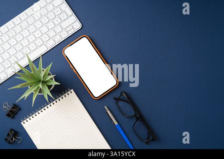 Top view of a workspace with a smartphone, notebook, pen, keyboard, and coffee Stock Photo