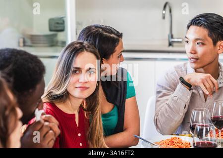 Young woman feeling uncomfortable during lunch with her friends, ignoring them Stock Photo