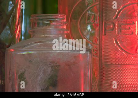 Crossville, TN USA - 03-03-2025 - Vintage glass bottles in close up with red glow in background Stock Photo