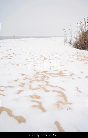 Snow-covered sand creating unique patterns on an Alabama beach Stock Photo