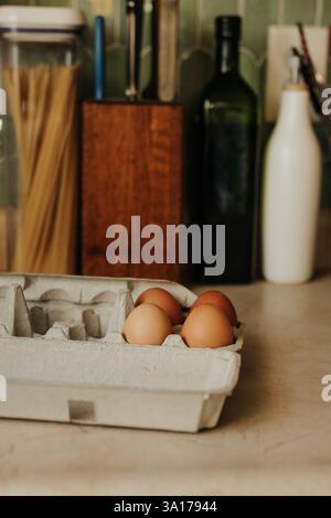 Almost empty carton of brown eggs sits on kitchen counter Stock Photo