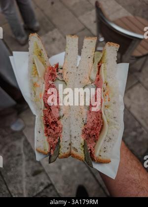 Reuben sandwich cut in half and held in hand Stock Photo