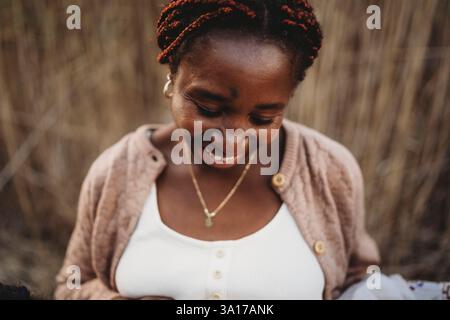 Happy black woman smiling looking down Stock Photo