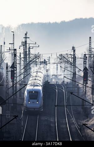 Deutsche Bahn AG tracks with ICE train against the light. Overhead line, signals and infrastructure. Railway tracks at the Geislinger Steige, Alb asce Stock Photo