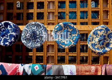 Ethnic colorful traditional hat tubiteika and bags with traditional uzbek ornament on street market in Khiva, Uzbekistan, Central Asia Stock Photo