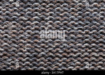 Close-up shot of knitted gray wool with maroon spots, offering a unique texture and color contrast, ideal for fabric or fashion-related projects Stock Photo