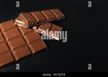 chocolate bar on black background. milk chocolate on black stone. from the edge of the frame. Stock Photo