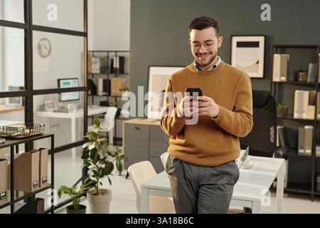 Young Man Using Phone in Office Stock Photo