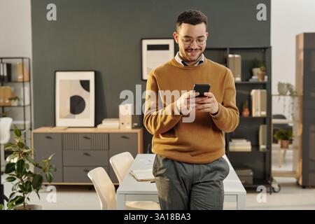 Young Man Using Smartphone in Office Stock Photo