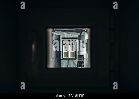A small attic window seen through another small attic window in the center of Lisbon Stock Photo