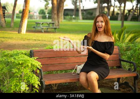 Woman in black dress posing in park during sunset Stock Photo