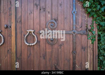 close-up of the handle and ironwork of an old rustic wooden door Stock Photo