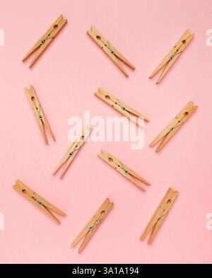 Wooden clothes pins on a pink background. Stock Photo