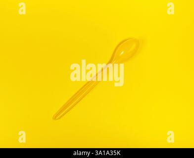 Big yellow spoon for food on yellow background. Same color concept. Stock Photo