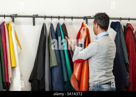 Shoes designer choose the right leather for making shoes. Stock Photo