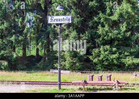 Old station lantern with town sign and bench made from rusty crash barriers... Stock Photo