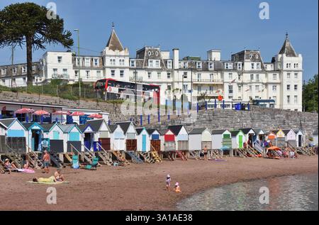 Torquay, Devon, beach, tourists, colorful beach huts, Grand Hotel Torquay in the background Stock Photo