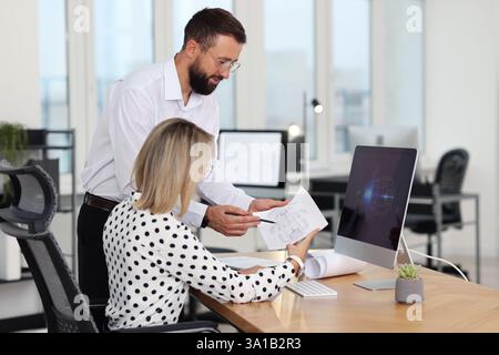 Technicians making digital engineering drawing on computer at desk in office Stock Photo